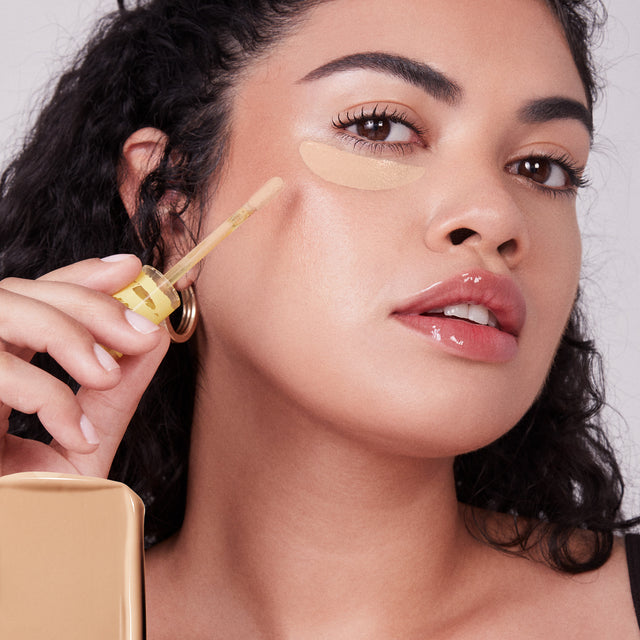 Model wearing Mini Revealer Concealer in Tone 06