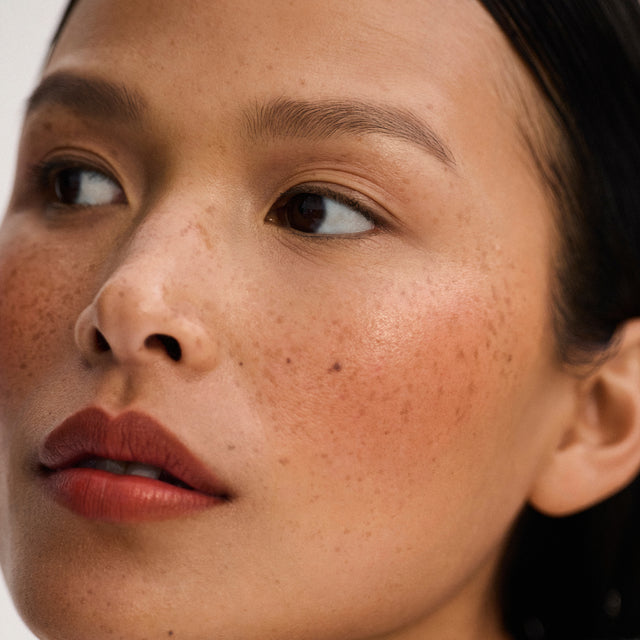 Medium skin tone model wearing Impressionist Multistick in Vital